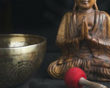 A statue of Buddha and a singing bowl