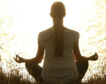 Woman meditating in front of water