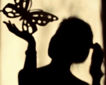 A girls shadow playing with a butterfly shadow